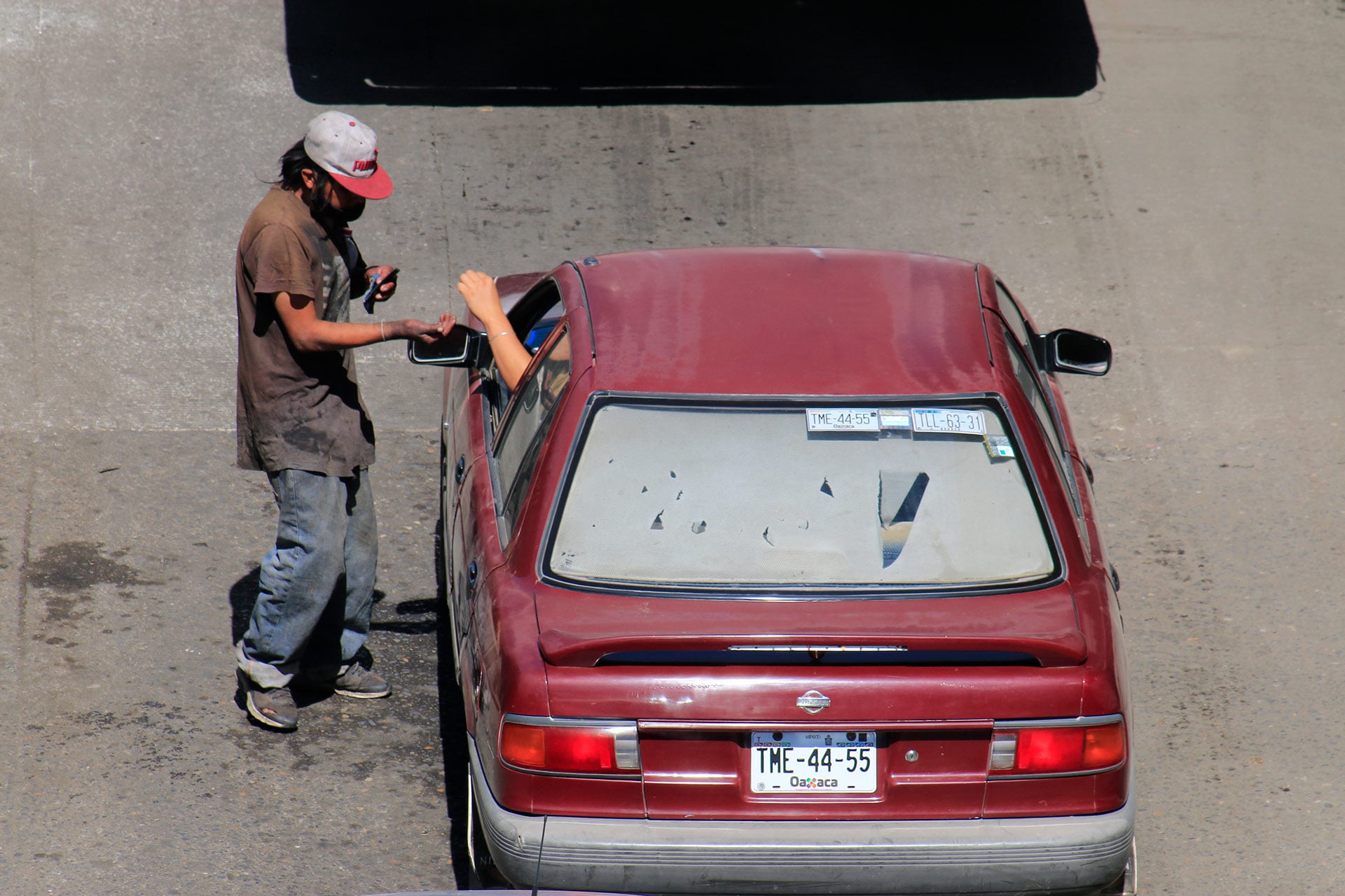 Limpiando cristales de los autos o haciendo mandados, así se buscan la vida.